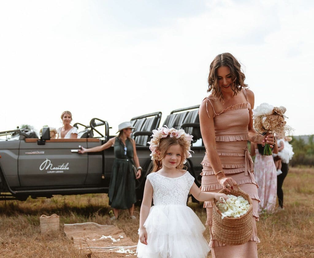 Bride sitting in game driver while bride's maid and little bride are walking towards the bush veld in South Africa Private Game reserve