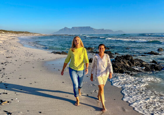 Two ladies walking along the beach with Table Mountain in the backdrop