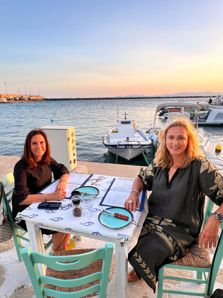 Two ladies eating at Tinos harbour