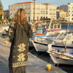 Lady walking at Tinos harbour in Greece. Frau spaziert am Hafen in Tinos