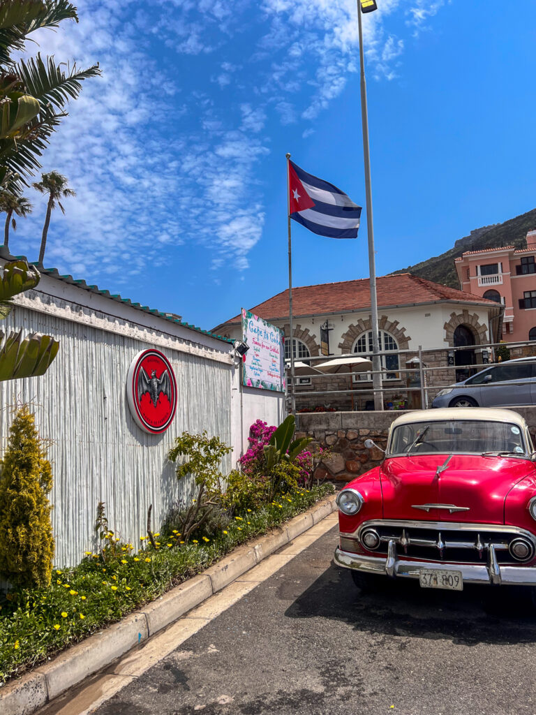 A red vintage car at the entrance of Cape To Cuba