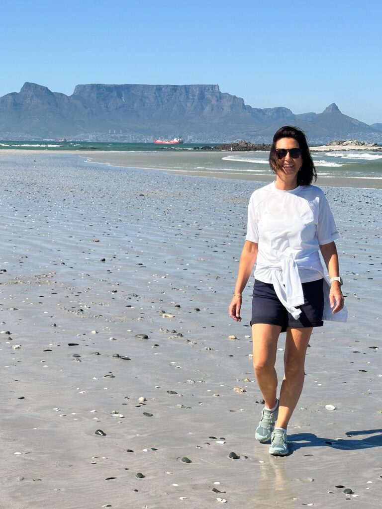 Lady walks on Bloubergstrand beach, Big Bay, Table Mountain