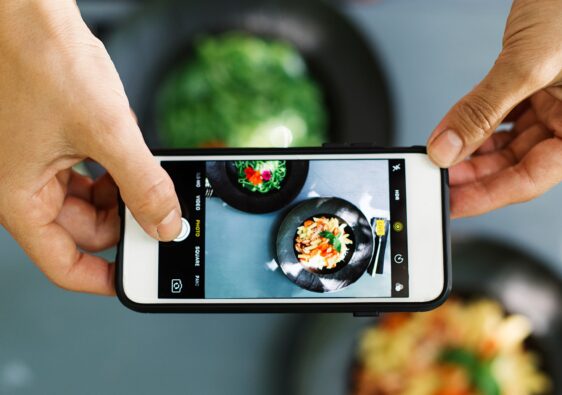 Top view of people using cellphone to take food photo